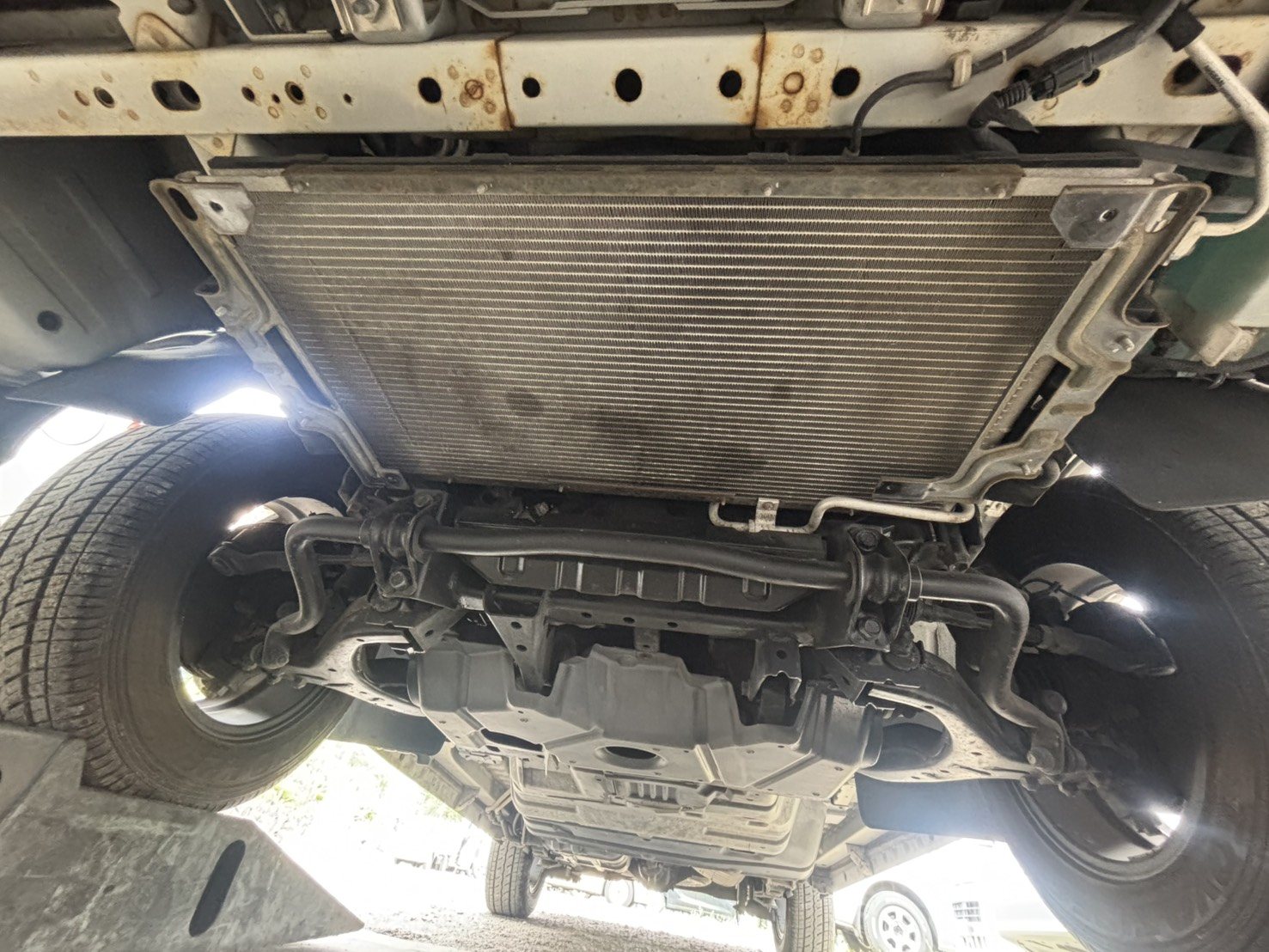 NV350キャラバン 交換前のA/Cコンデンサ(車両前方に装着された状態を下から撮影)